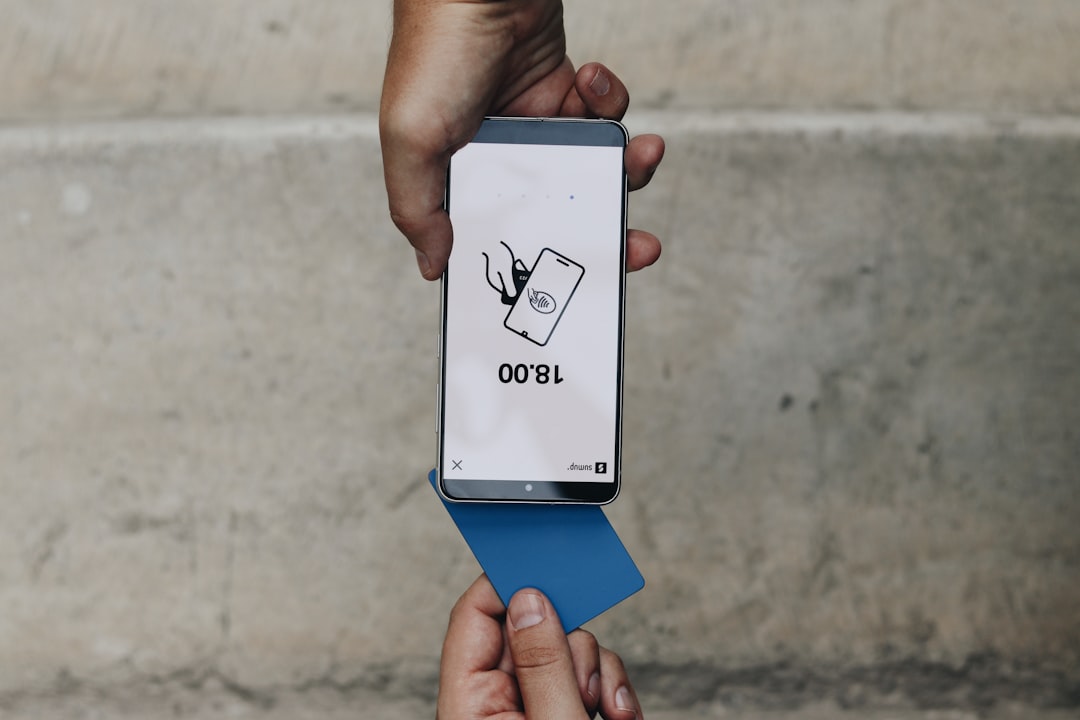 A person holding a smartphone using the Tap to Pay feature with a blue card. The screen displays the amount of 18.00, highlighting the fast and easy mobile payment experience.